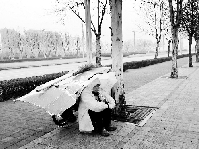 郑州环卫工雨天蹲路边休息 倒班房太远歇脚成问题